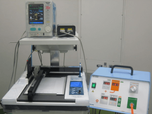 Operating-room view of a pneumatic tourniquet console beside a patient vital-signs monitor