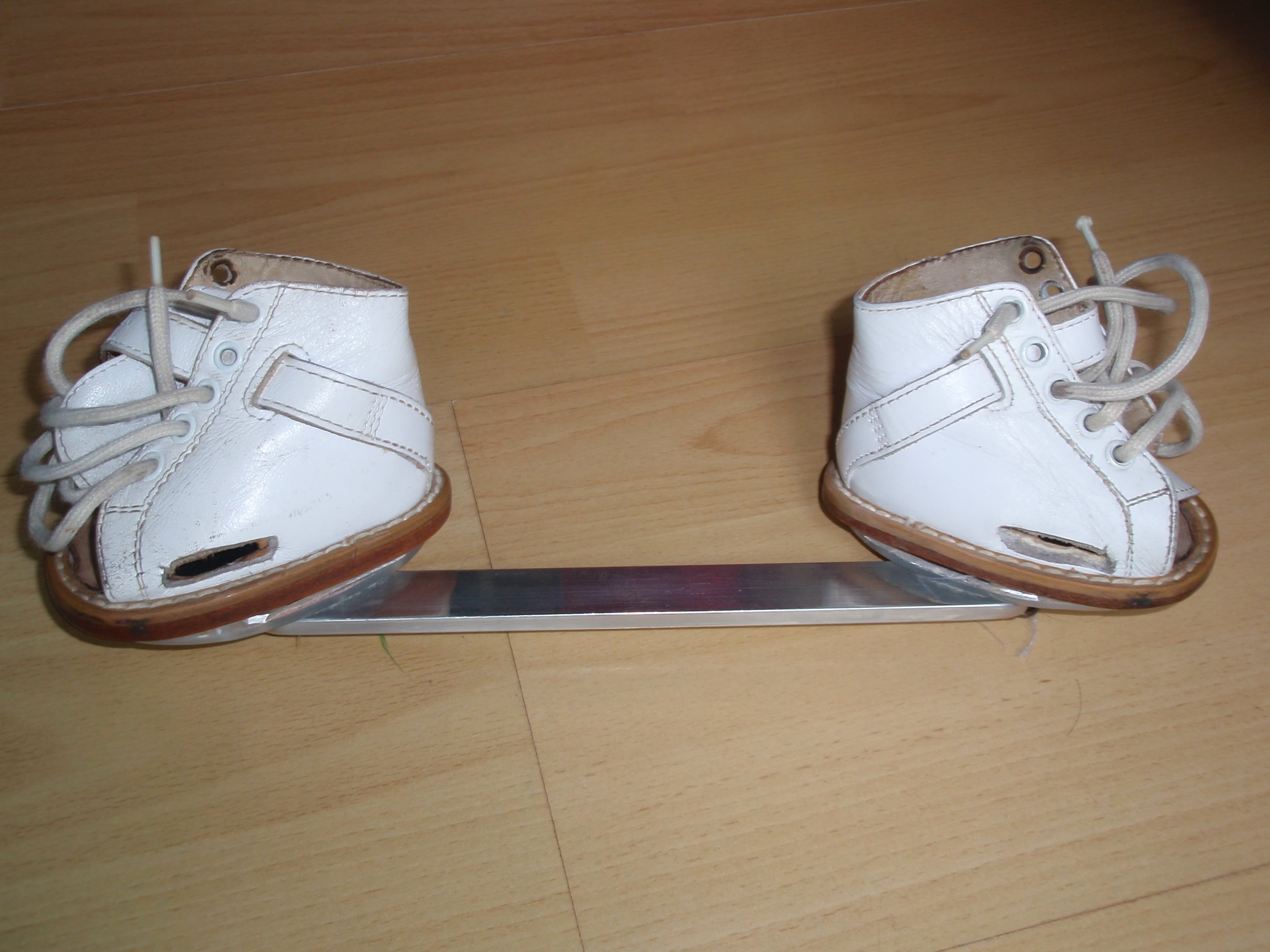Foot abduction orthosis - open-toe boots mounted on a bar.