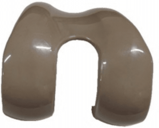 Photograph of a PEEK femoral component for total knee arthroplasty showing its contoured articulating surfaces