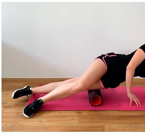 Foam-roller position with the roller beneath the lateral thigh, the supporting arm and crossed-over upper leg on the mat