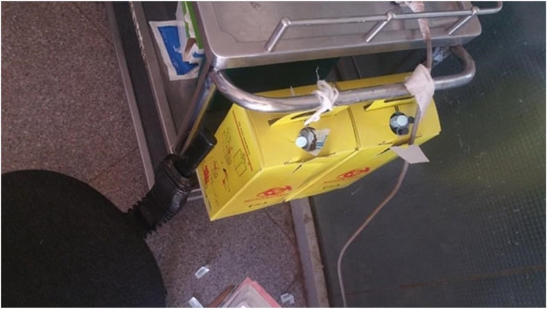 A filled sharps disposal container in a hospital emergency department