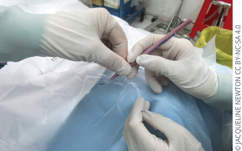 Gloved theatre staff passing a blade with the sharp end oriented away from the receiver.