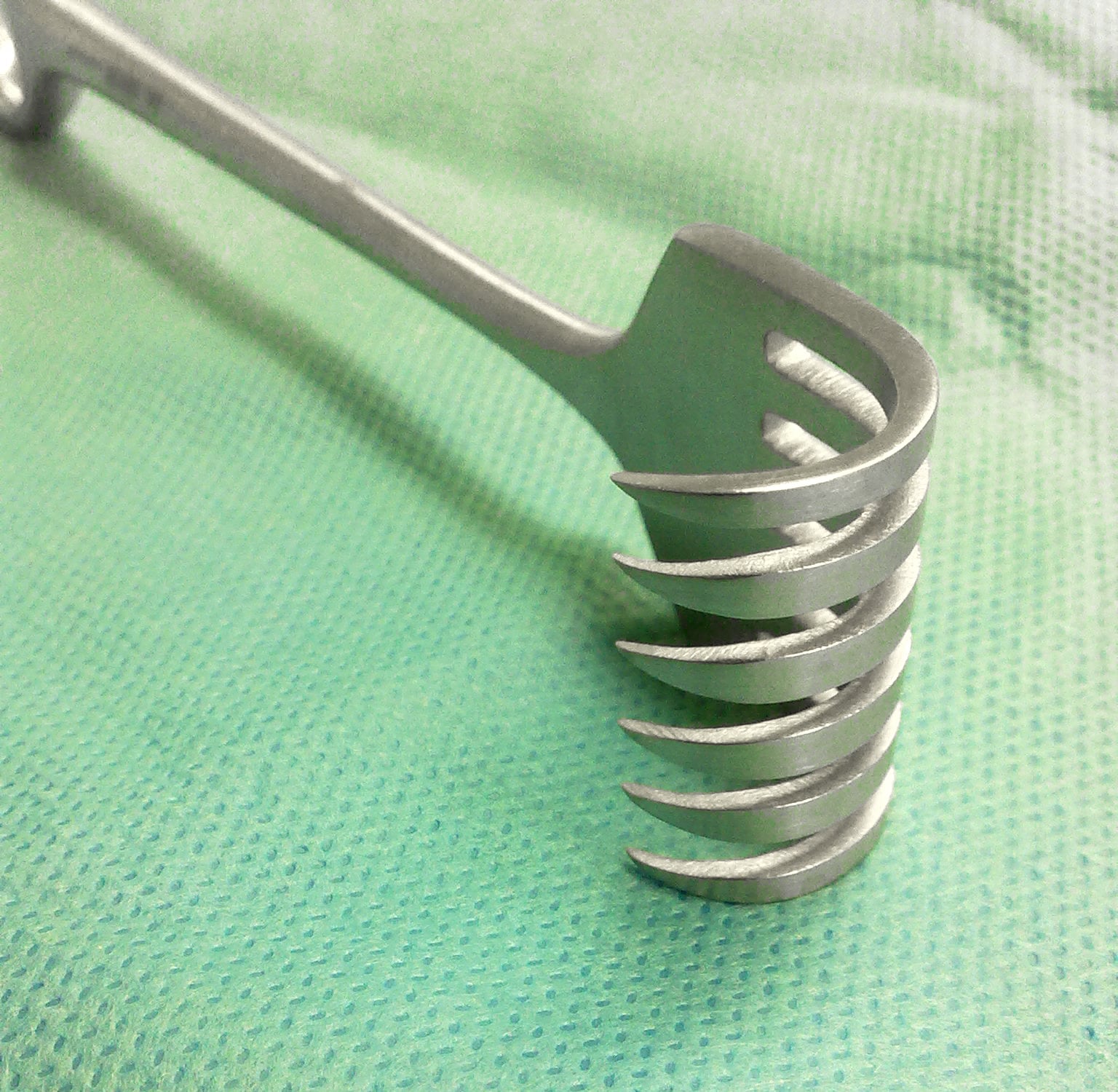 Volkmann rake retractor with a curved multi-pronged working end.