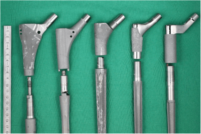 Five retrieved modular revision stems separated at the junction between proximal body and distal stem