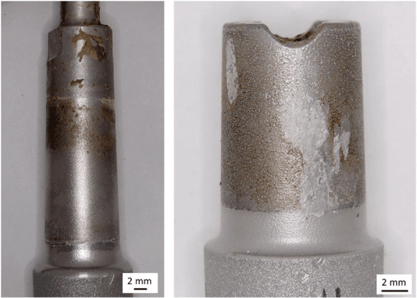 Two retrieved modular revision stem trunnions coated with adherent brown and white deposits